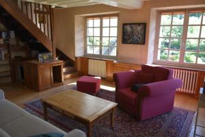 ein Wohnzimmer mit 2 Stühlen und einem Couchtisch in der Unterkunft Gite du Pont Saint-Céneri-Le-Gérei dans les Alpes Mancelles in Saint-Céneri-le-Gérei