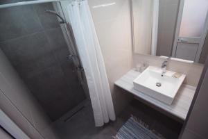 a bathroom with a sink, toilet and shower at Olympia Hotel in Sarandë