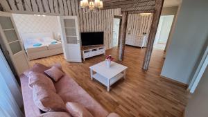 een woonkamer met een bank en een tv bij Kivi Residence in Pärnu