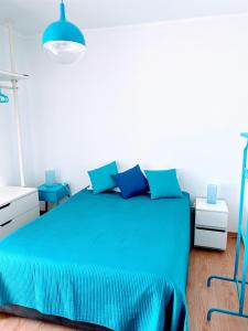ein Schlafzimmer mit einem blauen Bett mit blauen Kissen in der Unterkunft Costa Nova Beach View in Gafanha da Encarnação
