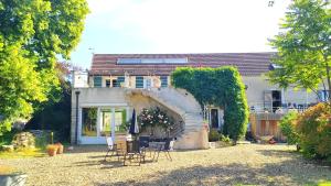 ein Haus mit einer Gruppe von Stühlen im Hof in der Unterkunft Clos des chenevières, 3 étoiles in Comblanchien