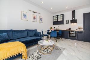 a living room with a blue couch and a table at Apartament w Sercu Gdańska in Gdańsk