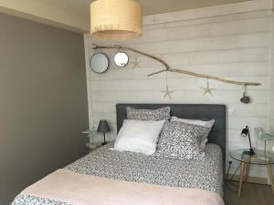 1 dormitorio con 1 cama con una rama en la pared en Le gîte du Petit Matelot, en Fécamp