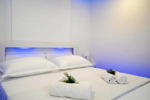 un letto bianco con due asciugamani e due cuscini di JURE a Sali (Sale)