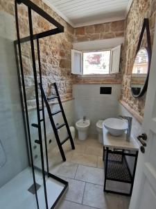 a bathroom with a toilet and a sink and a mirror at Casa Bellavista in Baunei
