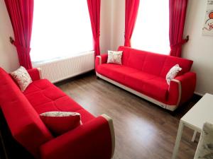 a red couch in a living room with red curtains at Istanberry - Berry Life Apartments in Istanbul