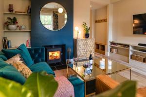 a living room with a blue couch and a fireplace at The Courtyard in Chichester