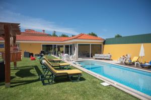 a swimming pool with lounge chairs next to a house at Quinta Salinas - Puro Prazer in Aveiro