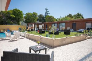 a building with a yard with chairs and a pool at Quinta Salinas - Puro Prazer in Aveiro