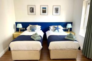 1 dormitorio con 2 camas individuales y toallas. en Ocean View Penthouse, The Harbour Mill, Westport, en Westport