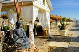 une statue d'un buddha assis dans le sable sur la plage dans l'établissement Villa Rosa a 50mt dal mare, à Gabicce Mare
