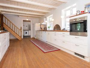 ØrstedにあるHoliday Home Gyvelvejの白いキャビネットと階段付きの広いキッチン