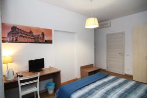 1 dormitorio con 1 cama y escritorio con ordenador en Bed and Breakfast Sognando Verso La Torre, en Pisa