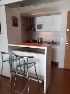 una cucina con due sgabelli e piano di lavoro di Maqui Departamentos a San Carlos de Bariloche