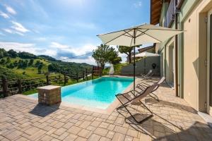 a swimming pool with a chair and an umbrella at Cascina Pajanòt in Benevello