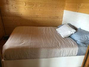 łóżko w pokoju z drewnianą ścianą w obiekcie Moinho de Vento (CASA DE MADEIRA) w mieście Castelo Branco