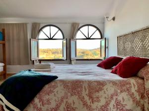 sypialnia z dużym łóżkiem i 2 oknami w obiekcie Santa Marta complejo rural con pista de padel w mieście Archidona