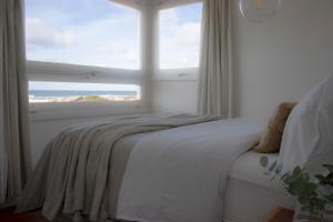 a bedroom with a bed and a large window at ALMAR- Punta Rubia, La Pedrera in La Pedrera