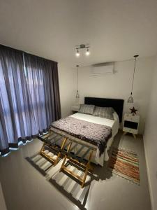 a bedroom with a large bed and a window at Depto en Complejo Ciudad Gama in Cordoba