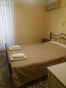 a bedroom with a bed with two towels on it at To Kyma-Afoi Roussou in Rovies