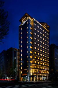 東京にあるホテル八重の翠東京の夜に照明が点灯する高層ビル