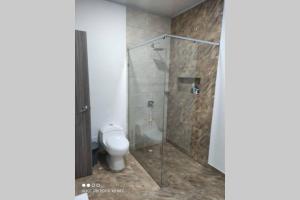 a bathroom with a toilet and a shower stall at Quinta SHADDAI MELGAR in Melgar