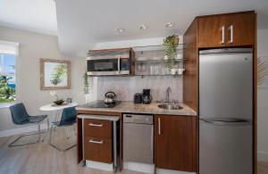 Una cocina con frigorífico de acero inoxidable y fregadero. en Strand Ocean Drive Suites, en Miami Beach