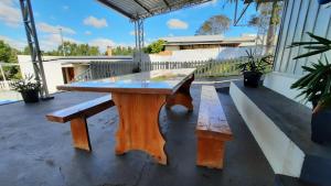 a wooden ping pong table and bench on a patio at Pousada Recriare in Campo Mourão