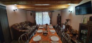 ein Esszimmer mit einem langen Tisch und Stühlen in der Unterkunft Balla House in Tărcaia