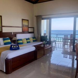 um quarto com 2 camas e vista para o oceano em Meditasi Bungalows & Villas em Amed