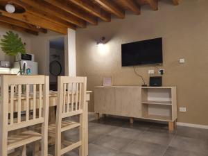 Una sala de estar con un televisor en la pared. en Centinelas del Paraiso, en Villa La Angostura