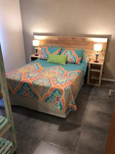 1 dormitorio con 1 cama con una manta colorida y lámparas en Centinelas del Paraiso, en Villa La Angostura 12 fotos más