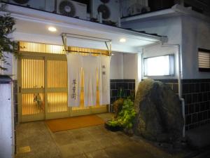 a bathroom with a shower and a door with a rock at Suihoukaku Hotel in Fukuoka