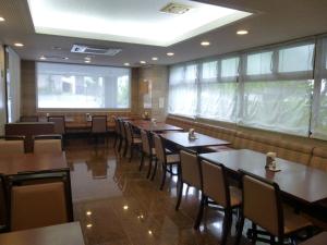 un restaurante con mesas y sillas de madera y ventanas en Suihoukaku Hotel en Fukuoka