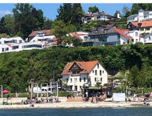 een groep gebouwen op een strand naast het water bij Gästehaus zum Felsen in Überlingen