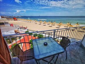 a balcony with a table and chairs and a beach at La Perla Bianca Residence in Eforie Nord