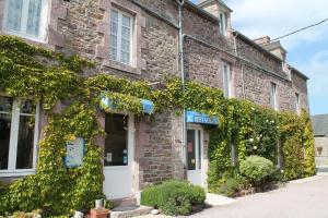 a brick building with ivy growing on it at Auberge l'Air de Vent in Frehel