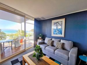 a living room with a couch and a view of the ocean at The Sandridge Motel in Lorne