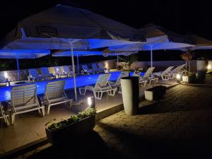 a patio area with umbrellas and chairs at Pension Riviera-Šilo in Šilo