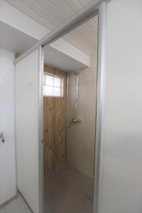 a bathroom with a shower with a sliding glass door at StrandGutkoje auf dem Campingplatz Strandgut in Cuxhaven