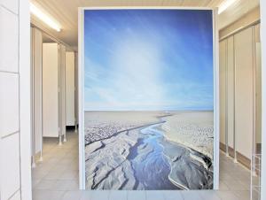 Offrant une vue sur la plage, cette chambre est ornée d'une fresque murale représentant une épée et un bâton. dans l'établissement StrandGutkoje auf dem Campingplatz Strandgut, à Cuxhaven