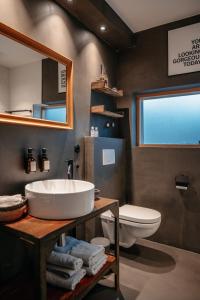 W łazience znajduje się umywalka, toaleta i lustro. w obiekcie Designapartment w mieście Wittenberga