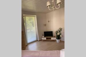 ein leeres Wohnzimmer mit einem TV und einer Couch in der Unterkunft Ferienhaus Bärbelstein / Wohnung Bärbelstein in Erlenbach