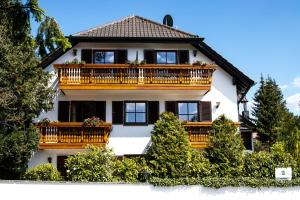 Großes weißes Haus mit Balkon in der Unterkunft Gästehaus Eder in Schrobenhausen