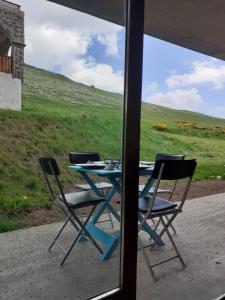 a table and chairs sitting on a porch with a view of a field at Appartement dans residence de tourisme in Besse-et-Saint-Anastaise
