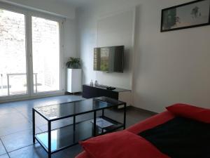 uma sala de estar com uma mesa de vidro e um sofá em kérentrée - Appartement en centre ville avec terrasse et parking privé em Pont-lʼAbbé