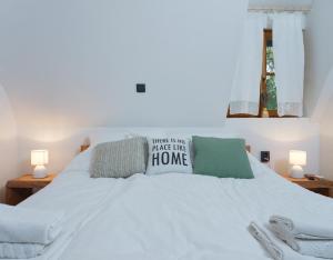 a white bed with two pillows on top of it at Yeti Cabin in Plitvica Selo