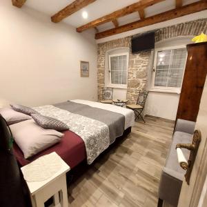 Schlafzimmer mit einem Bett, einem Stuhl und Fenstern in der Unterkunft Holiday Home Sea Beach Dvorska 37 in Crikvenica