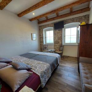 ein Schlafzimmer mit einem Bett und einem Sofa sowie zwei Fenstern in der Unterkunft Holiday Home Sea Beach Dvorska 37 in Crikvenica