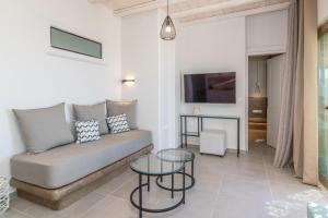 a living room with a couch and a glass table at Porto Bello Tinos in Agios Ioannis